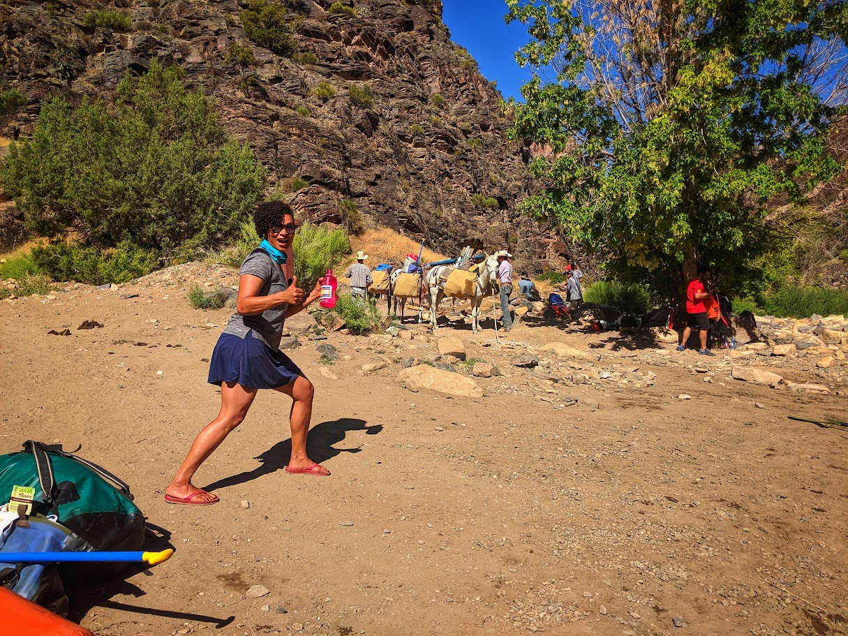 Amanda giving the thumbs up with mules in the background