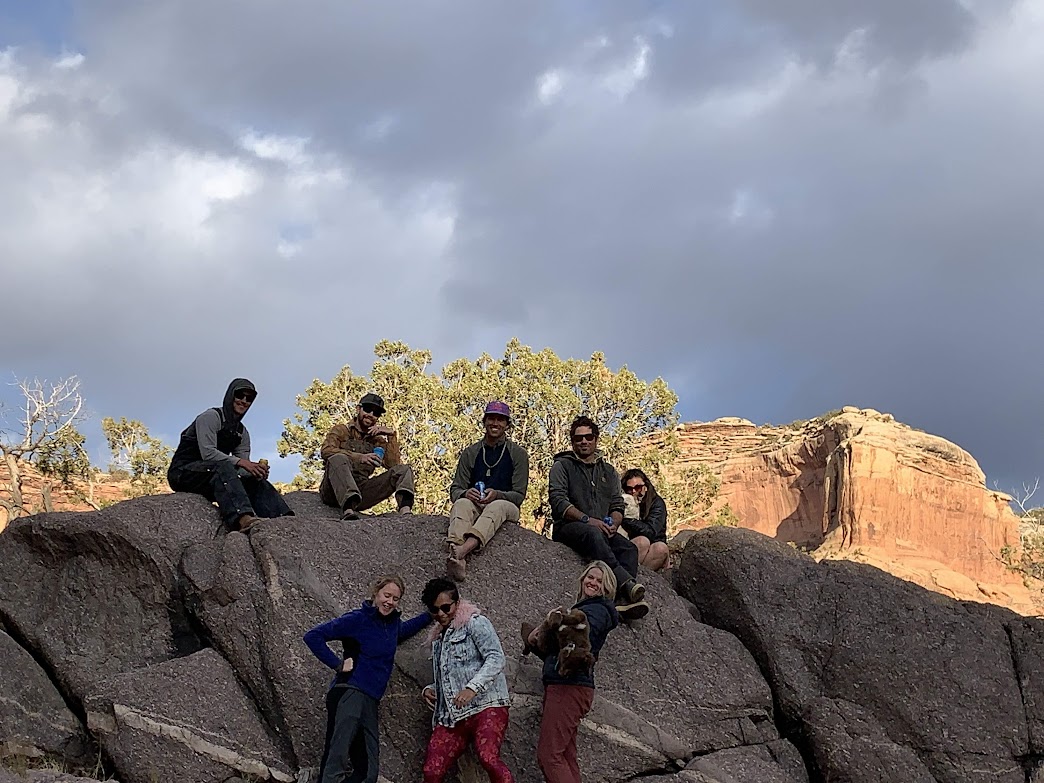 A group photo of the crew at sunset on the rocks