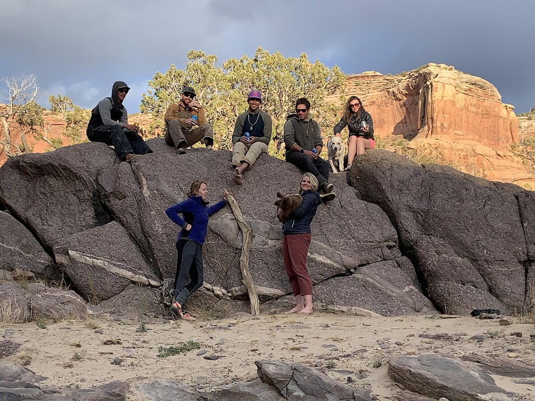 A group photo of the crew at sunset on the rocks